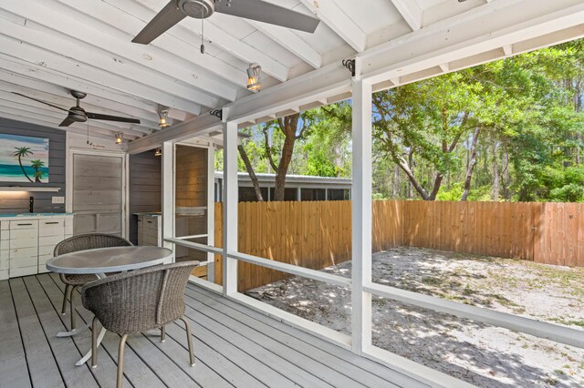 sunroom featuring beam ceiling and ceiling fan