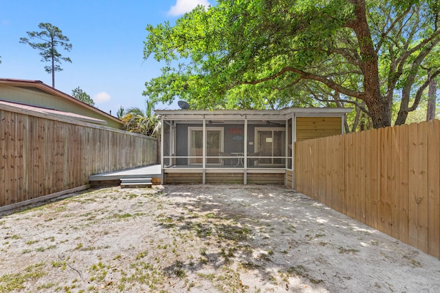 rear view of house featuring a sunroom and a fenced backyard
