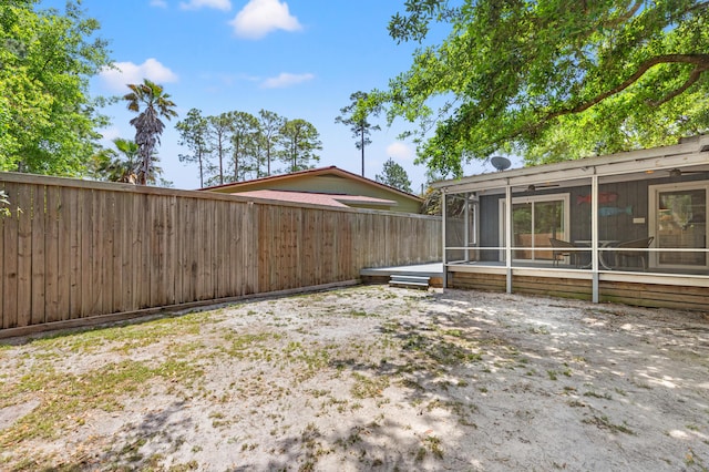 view of yard featuring a sunroom and a fenced backyard