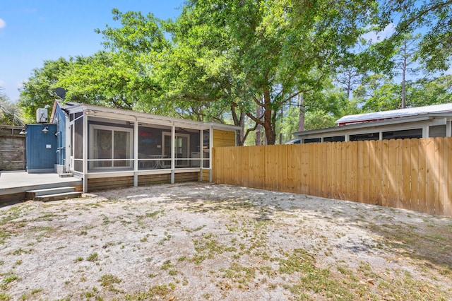view of yard with fence and a sunroom