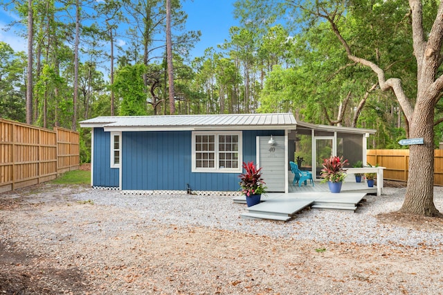 view of outbuilding featuring a sunroom and a fenced backyard