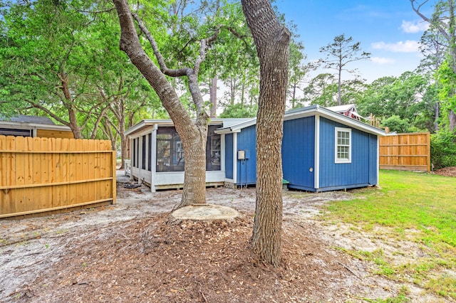 back of house featuring fence and a sunroom
