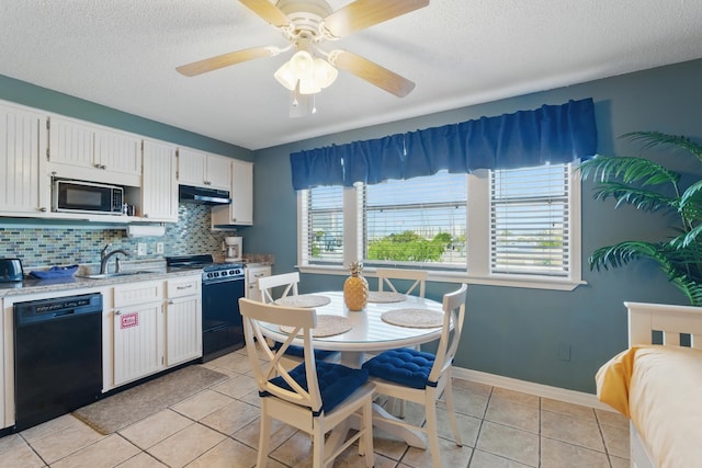 8730 Thomas Dr # 1210, Panama City Beach, FL 32408 - kitchen featuring light tile patterned floors, black dishwasher, under cabinet range hood, a sink, and gas range oven