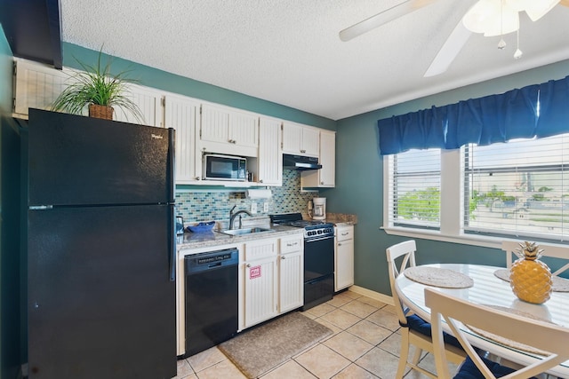8730 Thomas Dr # 1210, Panama City Beach, FL 32408 - kitchen featuring light tile patterned floors, a sink, under cabinet range hood, black appliances, and white cabinetry