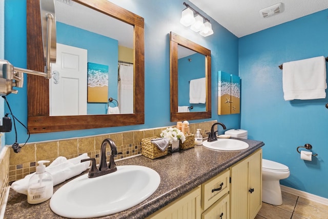 8730 Thomas Dr # 1210, Panama City Beach, FL 32408 - full bath with tile patterned floors, double vanity, a sink, and toilet
