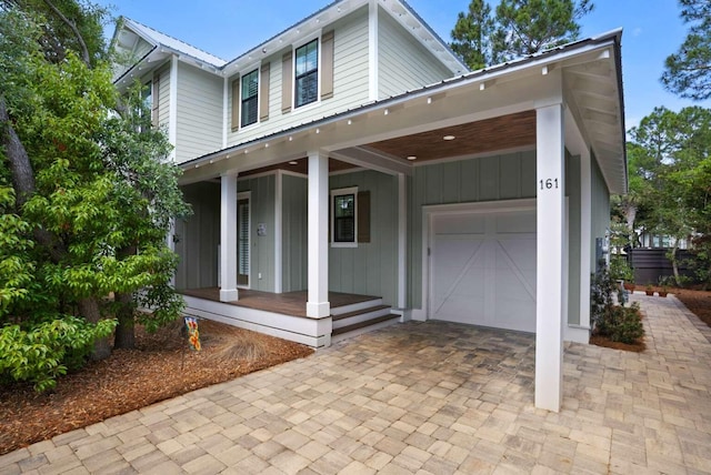 view of front of home featuring covered porch, board and batten siding, and decorative driveway