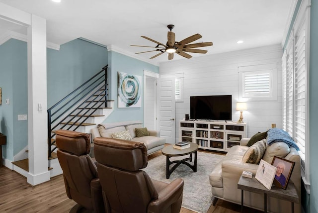 living area featuring a ceiling fan, wood finished floors, ornamental molding, stairway, and recessed lighting