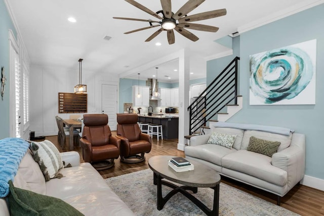 living room featuring ceiling fan, wood finished floors, stairway, baseboards, and recessed lighting
