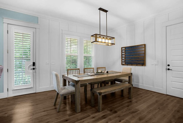 dining room featuring a decorative wall, dark wood-type flooring, and a chandelier