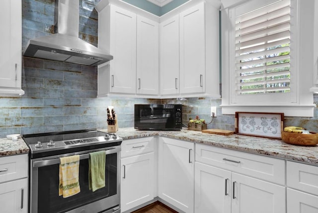 kitchen with stainless steel electric stove, wall chimney exhaust hood, white cabinets, and tasteful backsplash