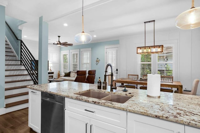 kitchen featuring dishwasher, a sink, ornamental molding, dark wood finished floors, and ceiling fan
