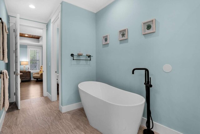 161 Lakewood Dr, Santa Rosa Beach, FL 32459 - ensuite bathroom featuring a soaking tub, baseboards, recessed lighting, and marble look tile flooring