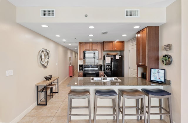 16701 Front Beach Rd Unit 1203, Panama City Beach, FL 32413 - kitchen featuring a peninsula, visible vents, baseboards, and black appliances
