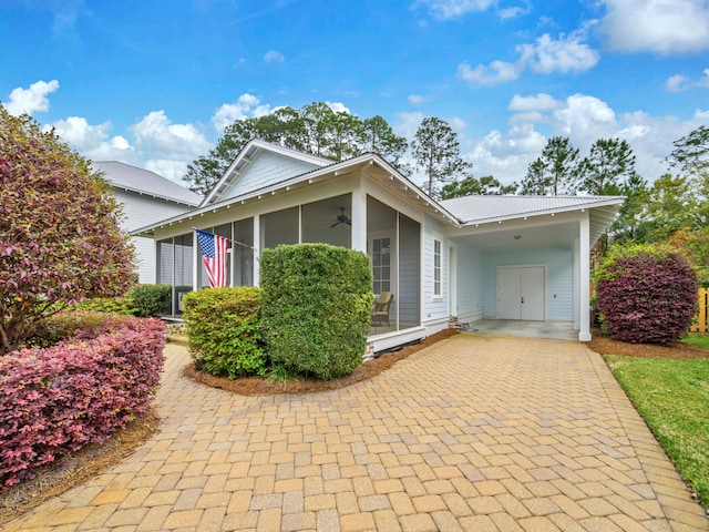 384 Carson Oaks Ln, Santa Rosa Beach, FL 32459 - view of front facade with a ceiling fan, a sunroom, decorative driveway, and an attached carport