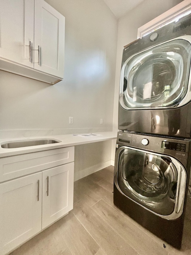 LOT11 E Georgie Pt, Washington, FL 32459 - clothes washing area with stacked washer and clothes dryer, cabinet space, and light wood finished floors