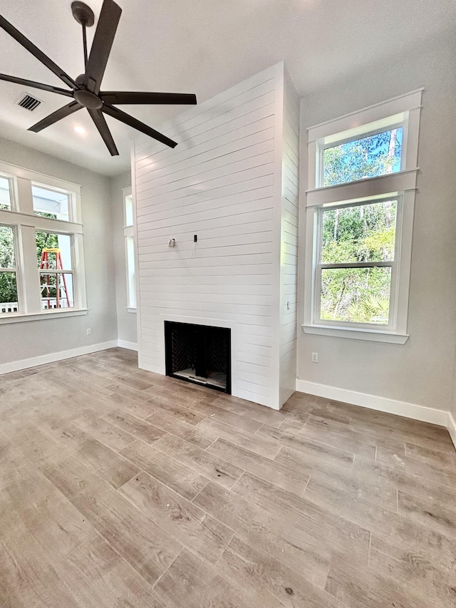 LOT11 E Georgie Pt, Washington, FL 32459 - unfurnished living room featuring ceiling fan, wood finished floors, a fireplace, and plenty of natural light