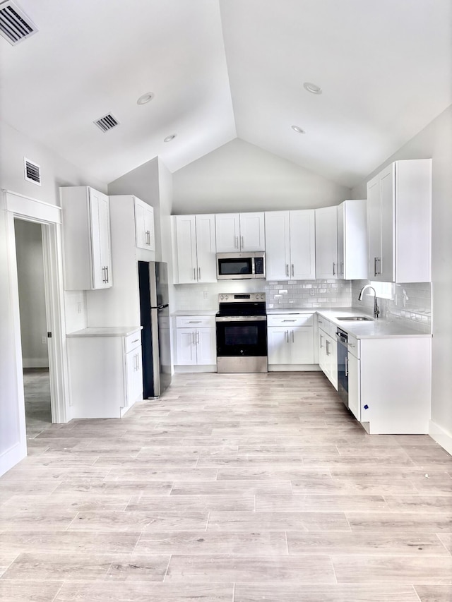 LOT11 E Georgie Pt, Washington, FL 32459 - kitchen featuring appliances with stainless steel finishes, lofted ceiling, a sink, light countertops, and tasteful backsplash
