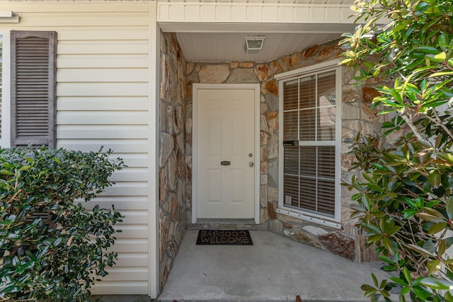 doorway to property featuring stone siding
