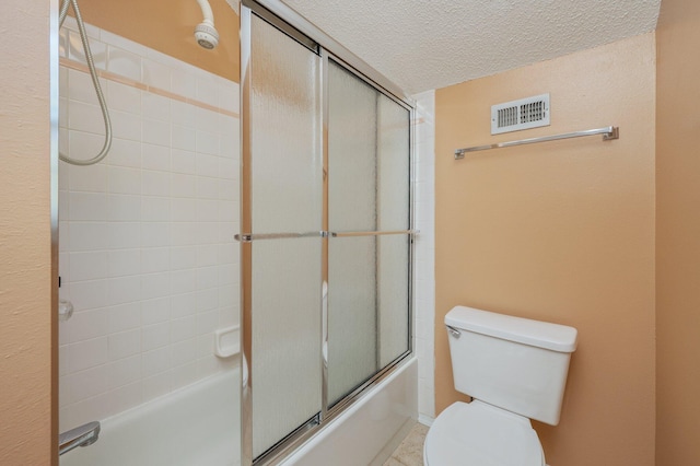 bathroom featuring a textured ceiling, visible vents, toilet, and bath / shower combo with glass door