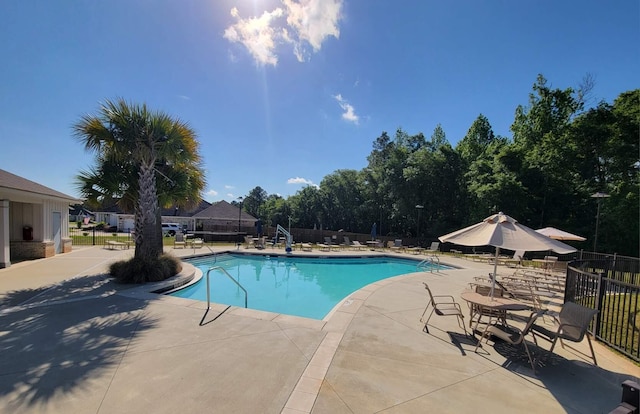 community pool with fence and a patio