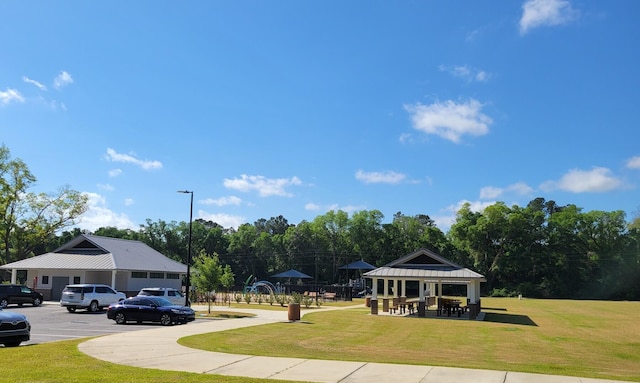 surrounding community with uncovered parking, a gazebo, and a yard