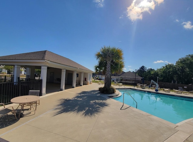 community pool featuring fence and a patio area