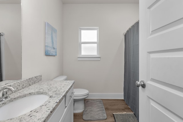 full bath with wood finished floors, toilet, vanity, a shower with curtain, and baseboards