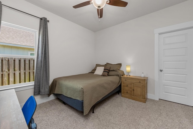 bedroom with ceiling fan, baseboards, and light colored carpet