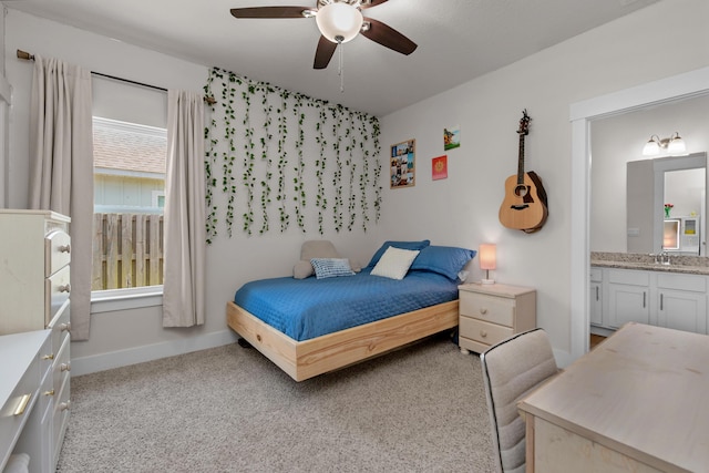 bedroom with light carpet, a sink, baseboards, ceiling fan, and ensuite bathroom