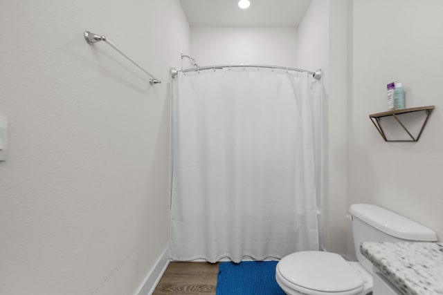 full bath featuring wood finished floors and toilet
