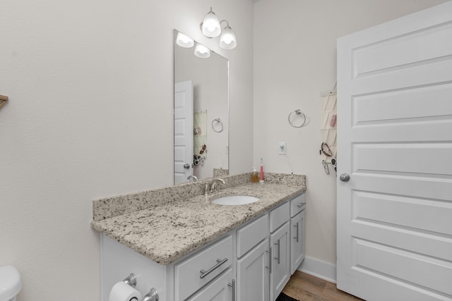 half bathroom featuring wood finished floors and vanity