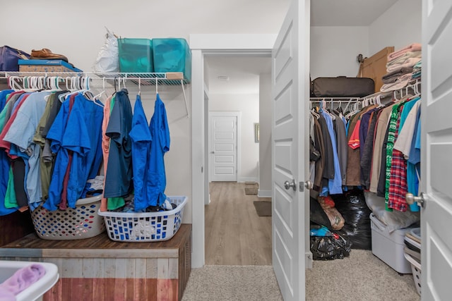 walk in closet with wood finished floors