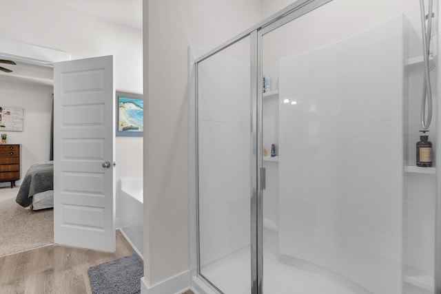 full bath with a shower stall, wood finished floors, and ensuite bathroom