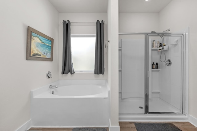 full bathroom featuring a garden tub, wood finished floors, and a shower stall