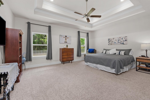 bedroom featuring a raised ceiling, carpet, baseboards, and multiple windows
