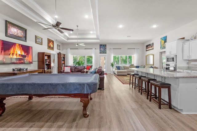 rec room with recessed lighting, billiards, a tray ceiling, a ceiling fan, and light wood-type flooring