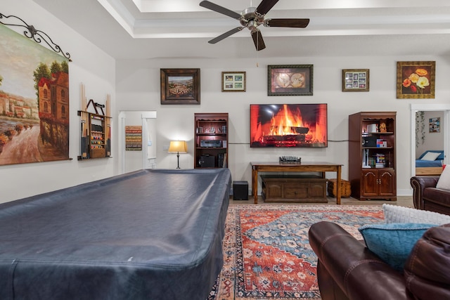 playroom with ceiling fan and a raised ceiling