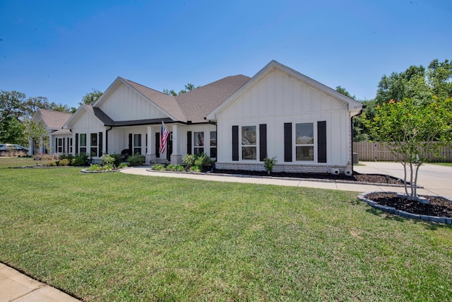 view of front of property featuring a front lawn, fence, and board and batten siding