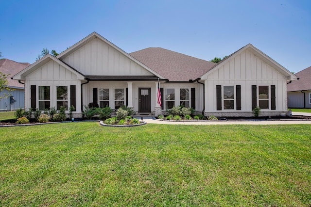 view of front of property with roof with shingles, board and batten siding, and a front yard