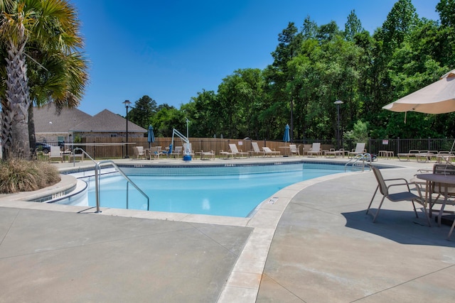 community pool featuring fence and a patio area