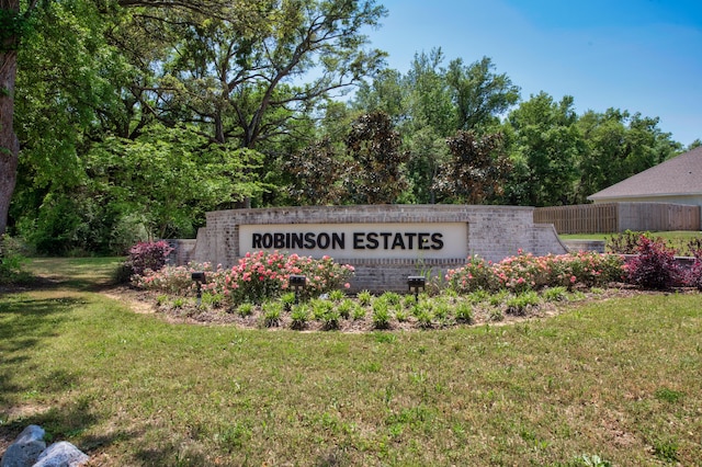 community sign with a lawn and fence