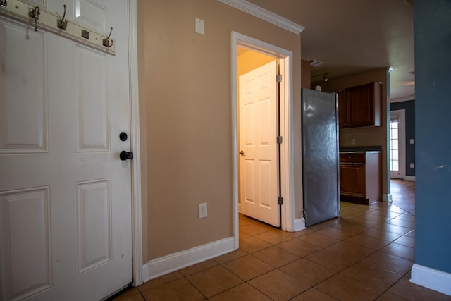 interior space featuring ornamental molding, baseboards, and light tile patterned floors