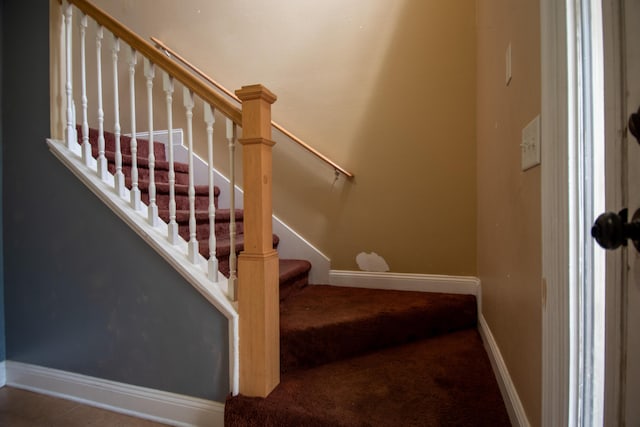 stairs featuring carpet flooring and baseboards