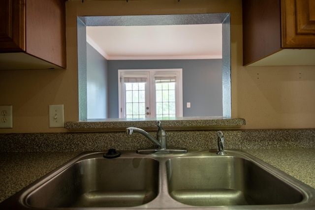details with brown cabinets, a sink, and crown molding