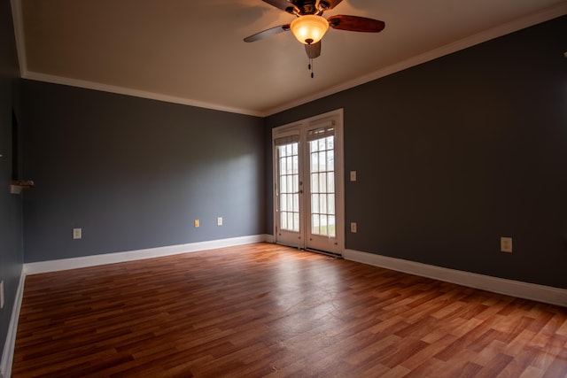 unfurnished room with crown molding, wood finished floors, baseboards, and a ceiling fan