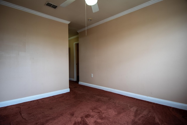 empty room featuring dark colored carpet, baseboards, crown molding, visible vents, and ceiling fan