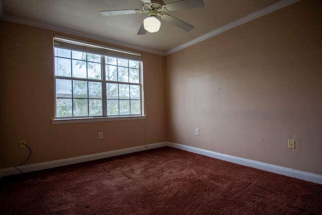 empty room featuring dark colored carpet, baseboards, crown molding, and ceiling fan