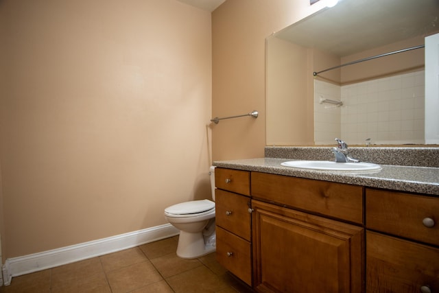 bathroom with vanity, baseboards, tile patterned floors, toilet, and a shower
