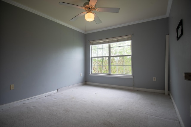 carpeted empty room with crown molding, baseboards, and a ceiling fan