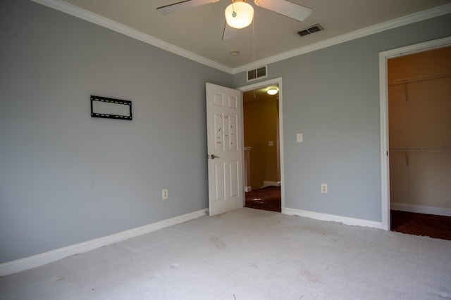 unfurnished bedroom featuring crown molding, carpet flooring, and visible vents